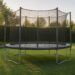 Trampoline in een tuin met veiligheidsnet en randkussen op een egaal oppervlak
