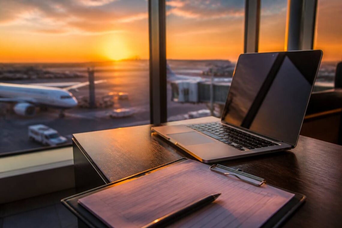 Checklist voor het vergelijken van vakanties op een tafel met laptop en reisnotities